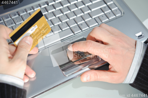 Image of notebook, credit card and man's hands