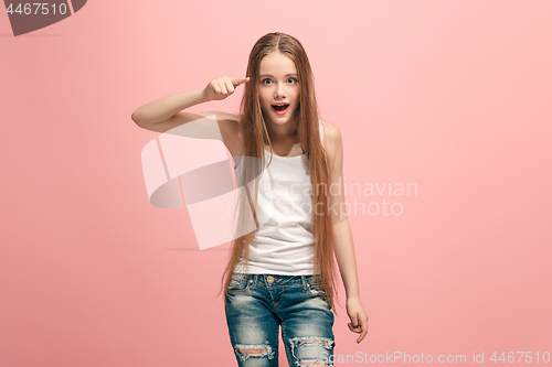 Image of The happy teen girl pointing to you, half length closeup portrait on pink background.