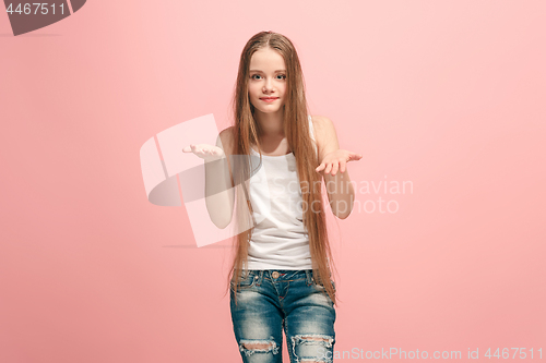 Image of The happy teen girl offering something against pink background.