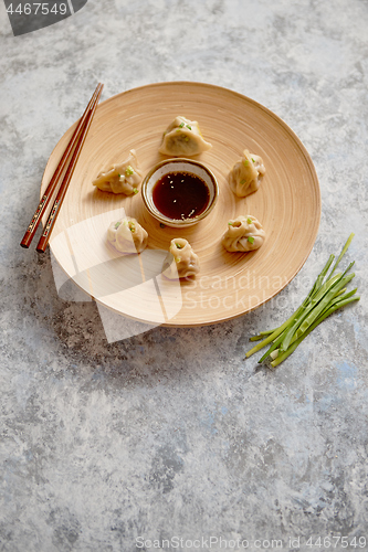 Image of Delicious chinese dumplings served on wooden plate