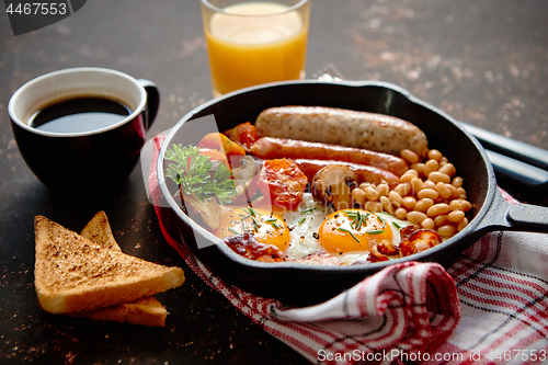 Image of Full English breakfast on dark rusty background