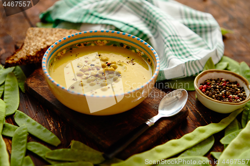 Image of Green pea cream soup in grey bowl