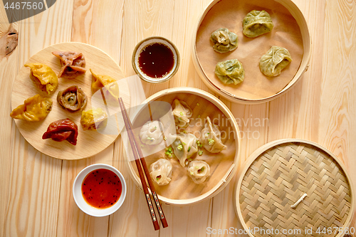 Image of Traditional chinese dumplings served in the wooden bamboo steamer