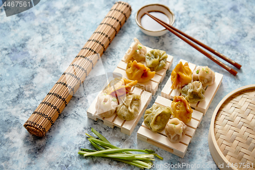 Image of Delicious mixed kinds of chinese dumplings served on wooden stands