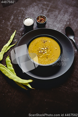 Image of Creamy soup with green pea in a ceramic white plate