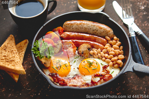 Image of Full English breakfast on dark rusty background