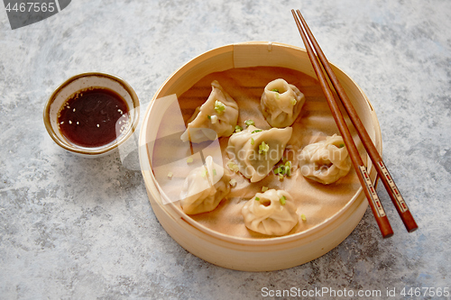 Image of Delicious chinese dumplings served in wooden bamboo steamer