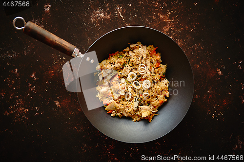 Image of Traditional orginal fried spicy rice with chicken served in a round iron wok