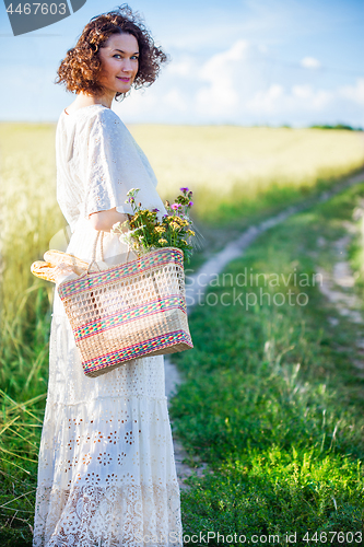 Image of woman in white dress with basket with bread and milk walking alo