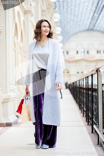 Image of Beautiful middle-aged woman with shopping bags