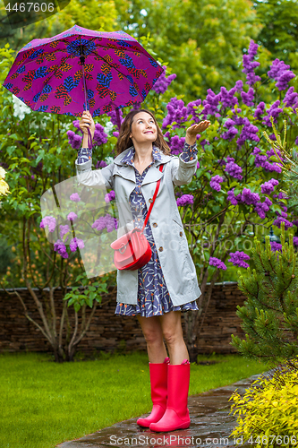 Image of beautiful woman with an umbrella and in a raincoat