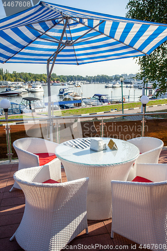 Image of cafe under a sun umbrella on the shore of yachting