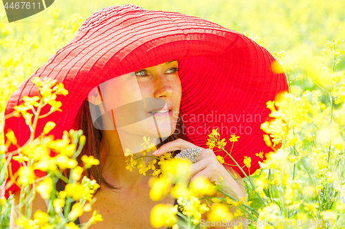 Image of woman in a red hat on a sunny day amidst wildflowers. portrait, 