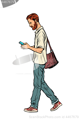 Image of Bearded male pedestrian looks at a mobile phone