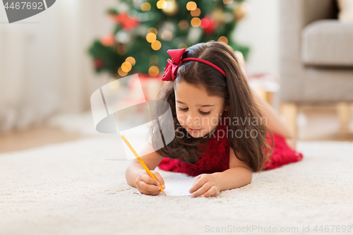 Image of little girl writing christmas wish list at home