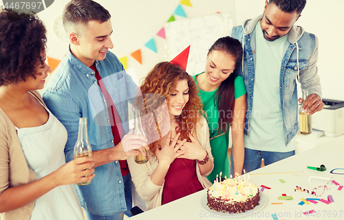 Image of happy coworkers with cake at office birthday party