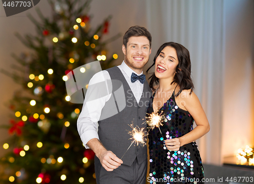 Image of happy couple with sparklers at christmas party