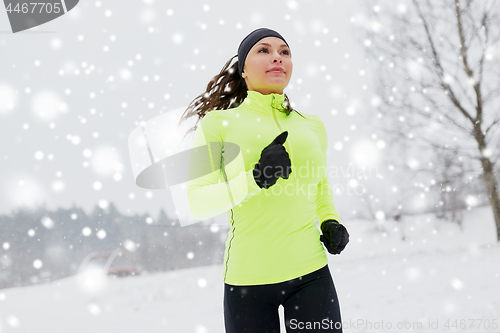 Image of happy woman running outdoors in winter