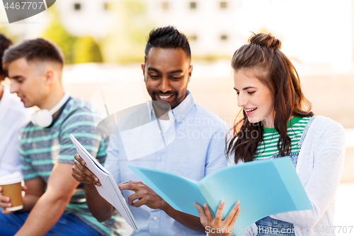 Image of international students with notebooks outdoors