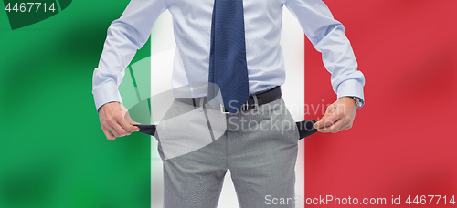 Image of businessman with empty pockets over flag of italy