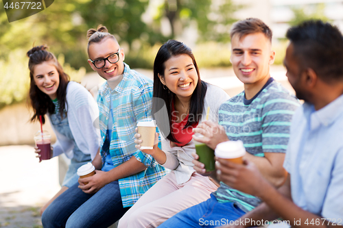 Image of friends drinking coffee and juice talking in city
