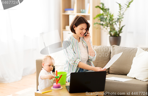 Image of working mother with baby calling on smartphone