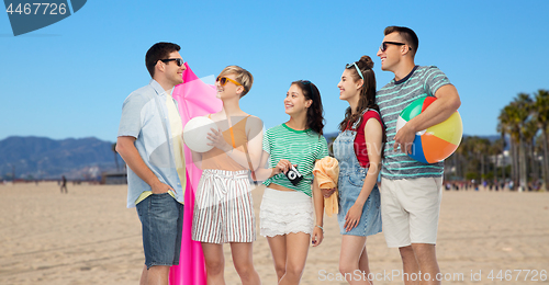 Image of happy friends with beach and summer accessories