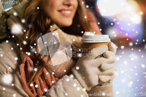 Image of happy woman with coffee over christmas lights