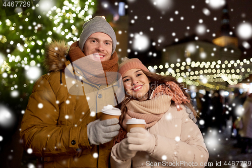 Image of happy young couple with coffee at christmas market