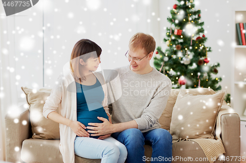 Image of pregnant wife with husband at home at christmas