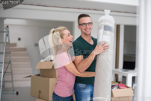 Image of couple carrying a carpet moving in to new home