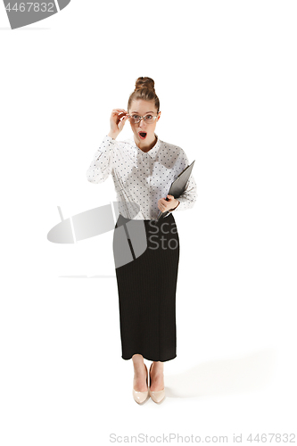 Image of Full length portrait of a surprised female teacher holding a folder isolated against white background