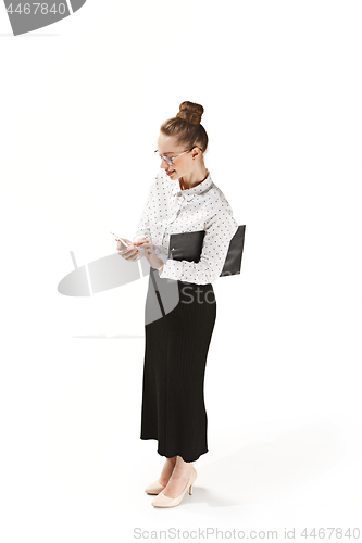 Image of Full length portrait of a smiling female teacher holding a folder isolated against white background