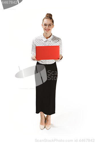 Image of Full length portrait of a smiling female teacher holding a laptop isolated against white background