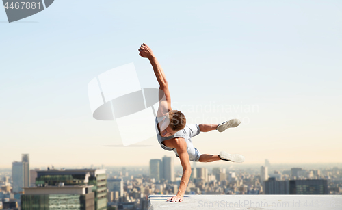 Image of man making parkour jumping over tokyo city