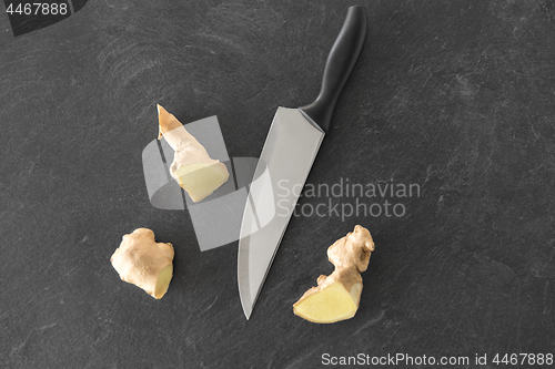 Image of close up of ginger root and knife on stone table