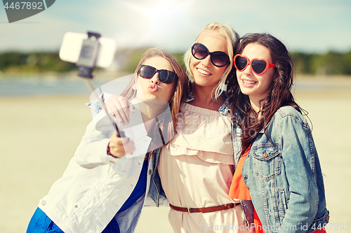 Image of group of smiling women taking selfie on beach