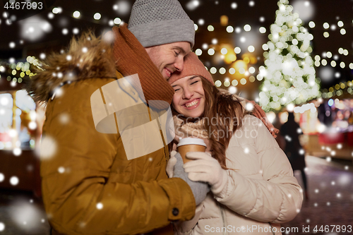 Image of happy young couple with coffee at christmas market