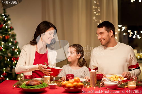 Image of happy family having christmas dinner at home