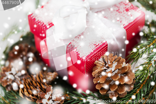 Image of close up of christmas gift and fir wreath on snow