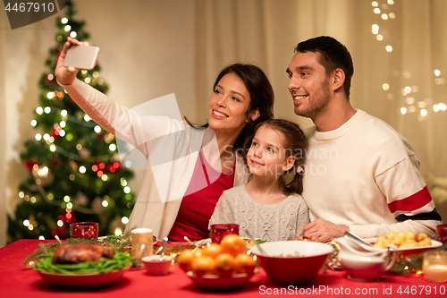 Image of happy family taking selfie at christmas dinner