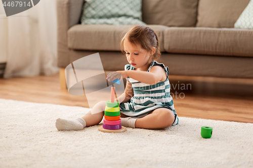 Image of happy baby girl playing with toy blocks at home