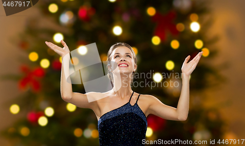 Image of beautiful woman over christmas tree lights