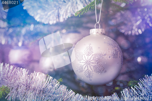 Image of Christmas-tree decoration bauble on decorated Christmas tree bac