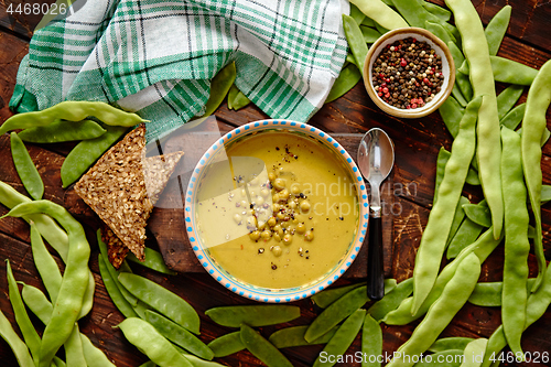 Image of Green pea cream soup in grey bowl