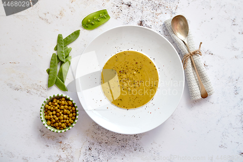 Image of Creamy soup with green pea in a ceramic white plate