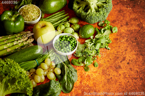 Image of Fresh green vegetables and fruits assortment placed on a rusty metal