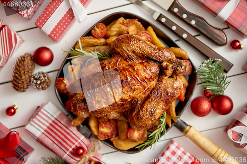 Image of Top view of Baked whole chicken or turkey served in iron square pan