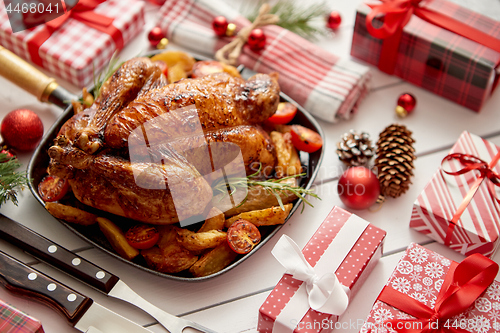 Image of Roasted whole chicken or turkey served in iron pan with Christmas decoration