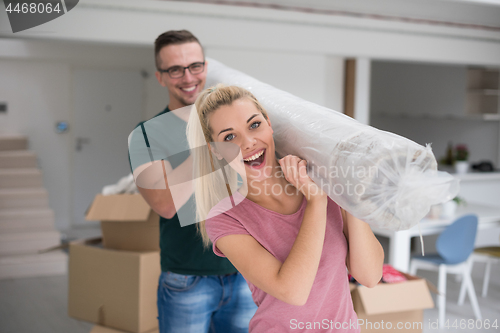 Image of couple carrying a carpet moving in to new home